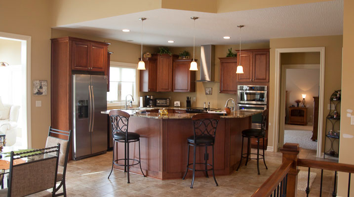 ICH Builders New Albany Ohio residence custom build showing cabinetry, sit-up dining area, lighting and flooring in the kitchen