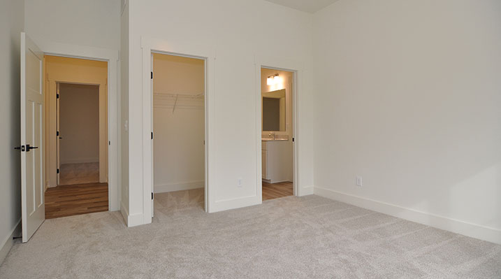 ICH Builders Dublin Ohio residence custom build bedroom with attached bathroom and view showing door