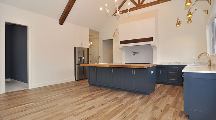 ICH Builders Dublin Ohio residence custom build open kitchen showing island, wood floors and vaulted ceilings with wooden beams