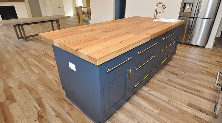ICH Builders Dublin Ohio residence custom build close up of kitchen island with dark blue base and a thick maple butcher block countertop