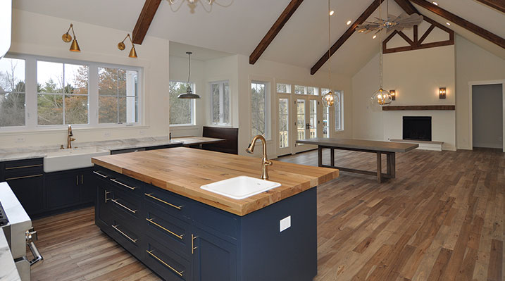 ICH Builders Dublin Ohio residence custom build on the main floor looking from the open kitchen towards the dining area and fireplace