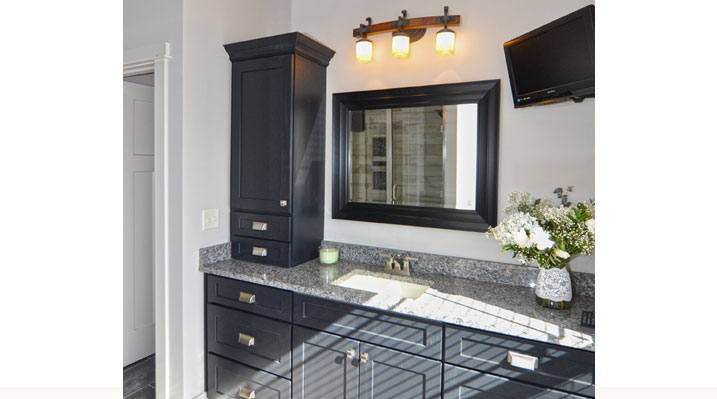 ICH Builders Berlin Ohio residence custom build view of bathroom vanity with dark wooden cabinets and drawers and gold fixtures