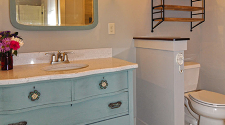 slider image of Berlin Ohio residence custom build bathroom with vintage-style blue painted vanity and mirror