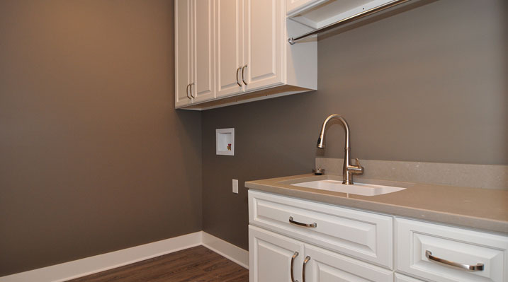 Iulianelli Custom Homes Lithopolis Ohio residence custom build laundry room with white cabinets and gold fixtures