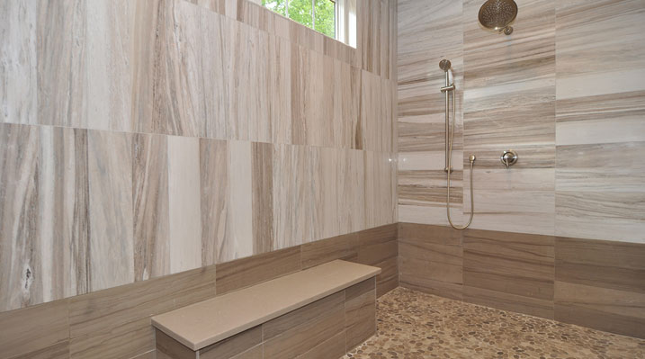 Iulianelli Custom Homes Lithopolis Ohio residence custom build master bathroom with modern walk-in shower featuring wood-look tile on the walls and a textured river stone floor