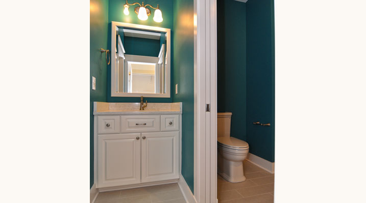 Iulianelli Custom Homes Lithopolis Ohio residence custom build second bathroom with dark blue walls, white vanity and gold fixtures