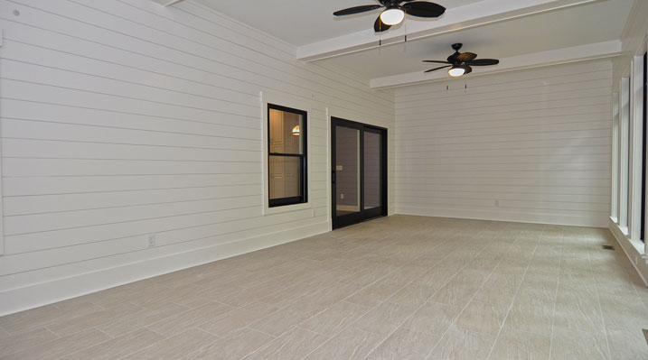 ICH Lithopolis Ohio residence custom build another view of the sun room showing the neutral-colored large tile floor and entrance to the main living area