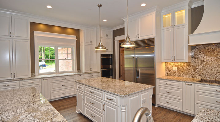 ICH Lithopolis Ohio residence custom build another view of the open kitchen area featuring a white galley island with gold fixtures topped by a Giallo Ornamental or Santa Cecilia Gold granite countertop