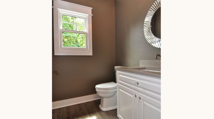 ICH Lithopolis Ohio residence custom build small bathroom with dark brown walls and white window trim and white vanity