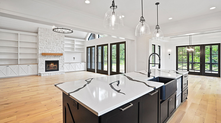 ICH Builders Canal Winchester Ohio residence custom build looking over the galley island with Calacatta Lumanyx style black and white countertop towards the main living area