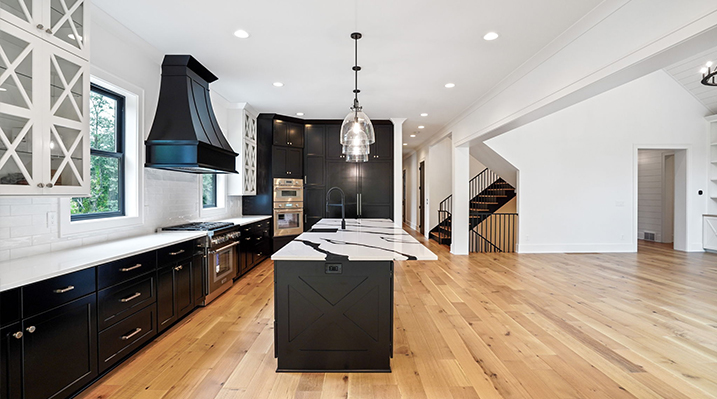 ICH Builders Canal Winchester Ohio residence custom build view of kitchen area with black range cover over the oven and industrial hanging lights over the island