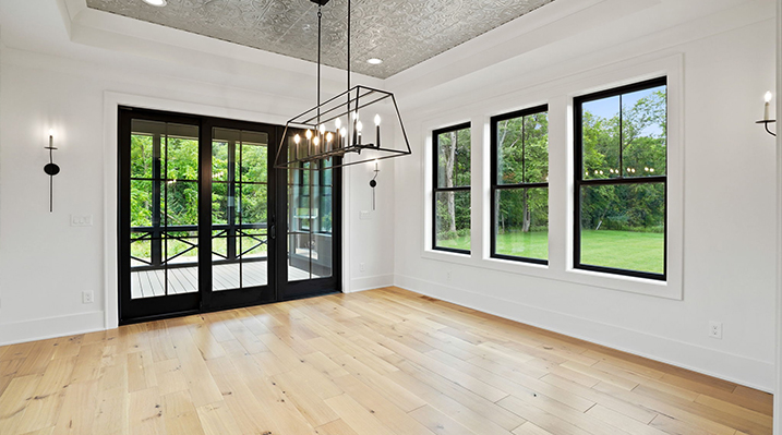 ICH Builders Canal Winchester Ohio residence custom build dining area with white walls, wooden floors and hanging linear pendant light fixture