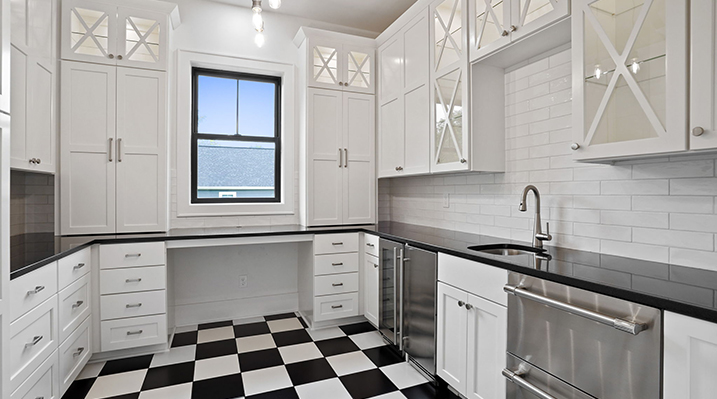 ICH Builders Canal Winchester Ohio residence custom build modern kitchen featuring white shaker cabinets, black countertops, and a black and white checkered floor