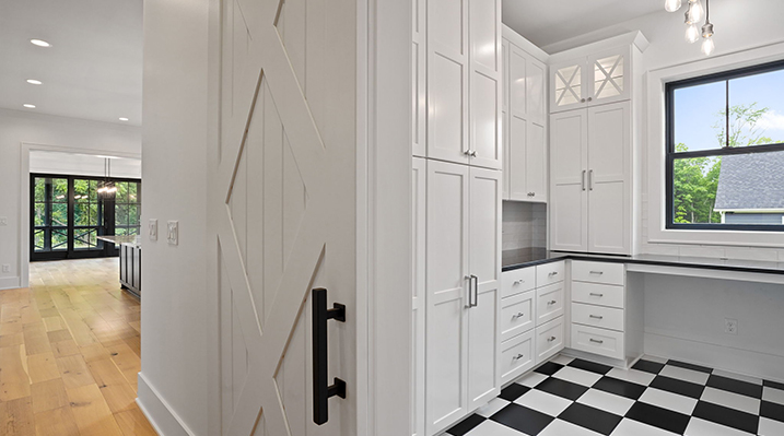 ICH Builders Canal Winchester Ohio residence custom build another view of the modern kitchen featuring white shaker cabinets, white fixtures, and a black and white checkered floor