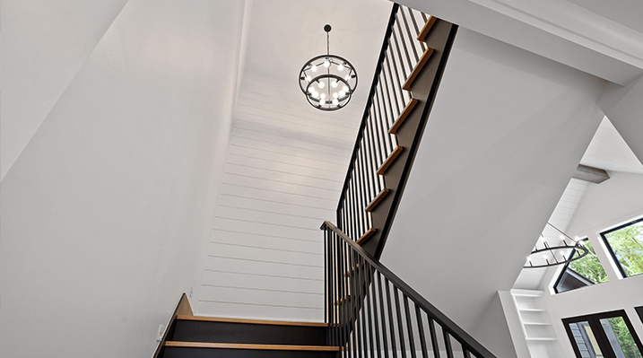 ICH Builders Canal Winchester Ohio residence custom build view looking up the stairs towards upper level and hanging chandelier