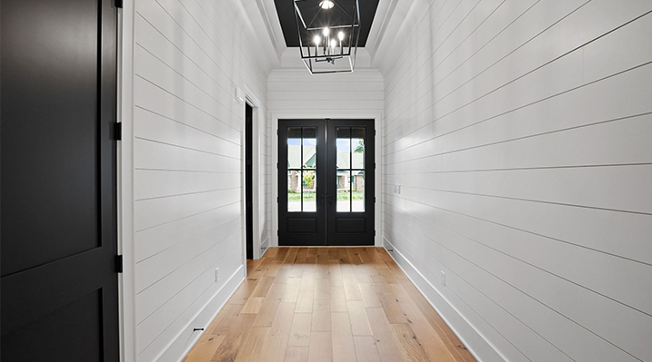 ICH Builders Canal Winchester Ohio residence custom build looking down hallway lined with white walls towards black doors