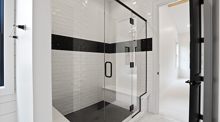 ICH Builders Canal Winchester Ohio residence custom build focusing on the clear glass enclosed black and white shower in the bathroom