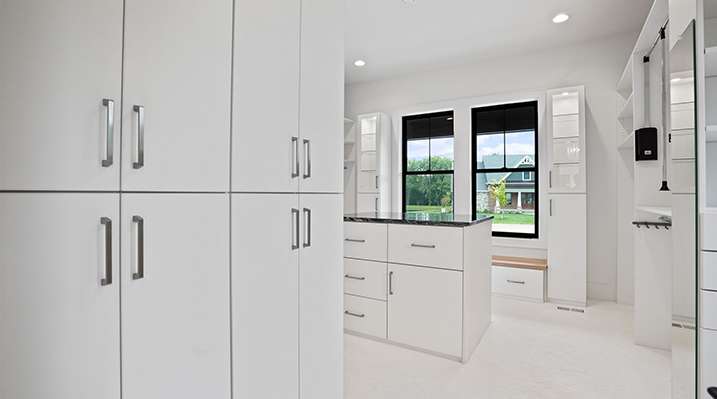 ICH Builders Canal Winchester Ohio residence custom build massive walk in closet with white cabinets and drawers with silver fixtures