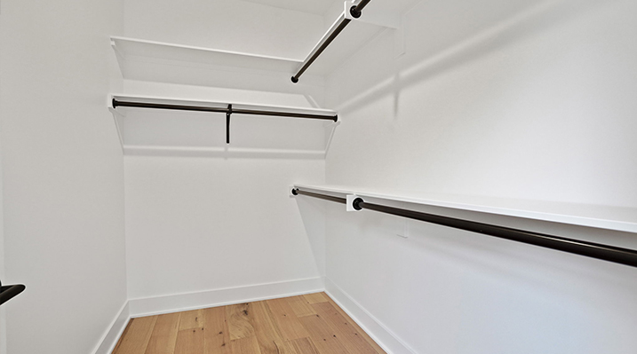 ICH Builders Canal Winchester Ohio residence custom build detailed view of walk in closet with white walls and shelves and black closet rods