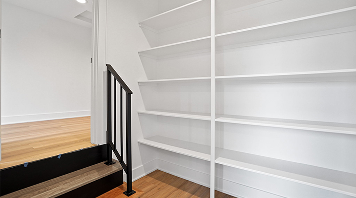 ICH Builders Canal Winchester Ohio residence custom build close up of white shelving with 2 step stair and black railing