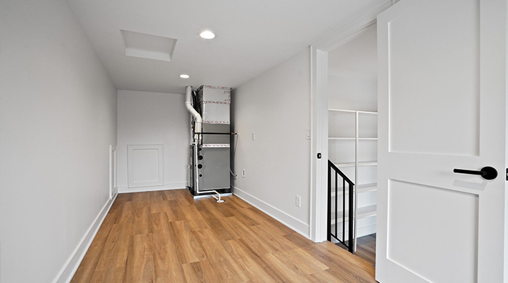 ICH Builders Canal Winchester Ohio residence custom build separate room in basement with white walls and wooden floors with furnace in the back corner