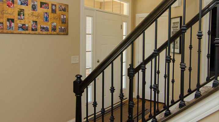 Iulianelli Custom Homes Belmont Model looking at the front door through the railings of the stairs