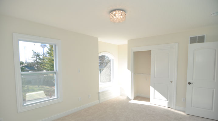 Iulianelli Custom Homes Oakland Model upstairs bedroom showing closet space and arched window